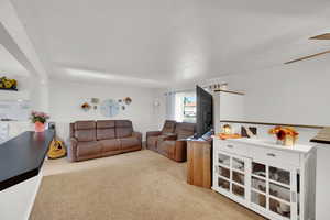 Living room featuring carpet and a textured ceiling