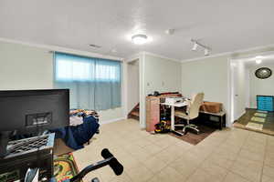 Office area with ornamental molding, track lighting, light tile patterned floors, a textured ceiling, and baseboards