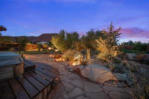Patio terrace at dusk with a patio area, a hot tub, and grilling area