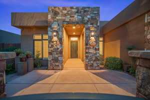 View of exterior entry with stone siding and stucco siding
