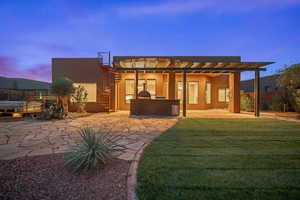 Back of property featuring stucco siding, stairway, a patio, and a yard