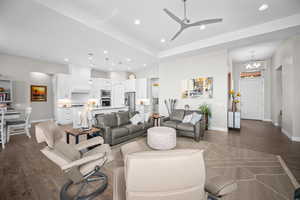 Living room featuring dark wood-style flooring, recessed lighting, a chandelier, baseboards, and ceiling fan