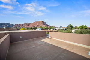 View of patio / terrace with a mountain view and a gate