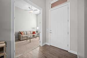 Foyer featuring dark wood finished floors, a ceiling fan, and baseboards