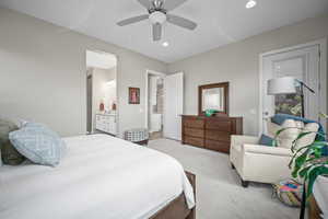 Bedroom featuring light colored carpet, recessed lighting, ensuite bath, and ceiling fan