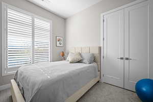 Carpeted bedroom with a closet and baseboards