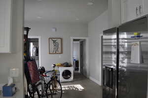 Laundry area with wood finished floors, baseboards, and recessed lighting