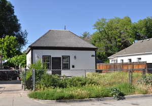 Rear view of property featuring a gate and roof with shingles