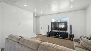 Living room with light colored carpet, recessed lighting, and baseboards