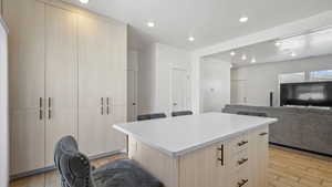 Kitchen with a kitchen island, recessed lighting, light countertops, modern cabinets, and light wood-type flooring