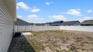 View of yard with cooling unit and a residential view