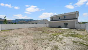 Rear view of property featuring a mountain view, a patio area, a fenced backyard, and central air condition unit