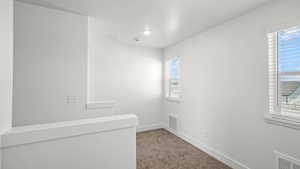 Empty room featuring carpet flooring and baseboards