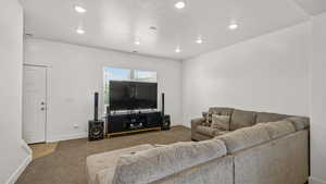 Living area featuring carpet flooring, baseboards, and recessed lighting