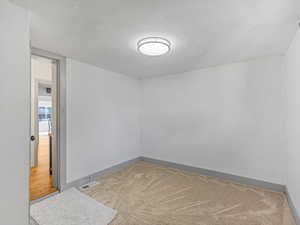 Carpeted spare room with baseboards