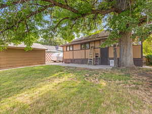 Back of property with a lawn and a patio area