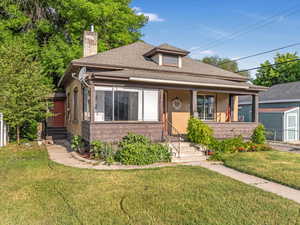 Bungalow with entry steps, a chimney, a shingled roof, and a porch