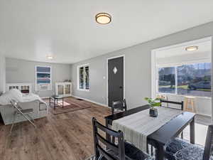 Dining space with wood finished floors, cooling unit, and baseboards