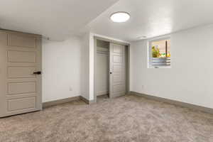 Unfurnished bedroom featuring carpet flooring, baseboards, and a closet