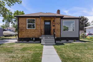 Bungalow-style house with a chimney and a front lawn