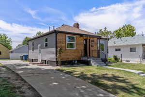 View of front of property with a chimney and a front yard