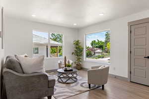 Living area featuring light wood-style flooring, baseboards, recessed lighting, and a textured ceiling