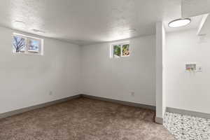 Below grade area with carpet, a textured ceiling, and baseboards