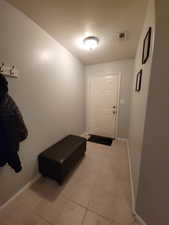 Doorway to outside featuring baseboards and light tile patterned flooring