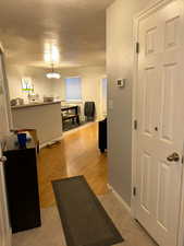 Hall featuring a textured ceiling, baseboards, light tile patterned floors, and a chandelier