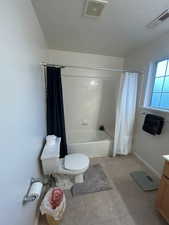 Full bath with toilet, shower / tub combo, vanity, tile patterned floors, and baseboards