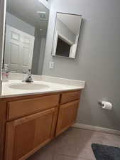 Bathroom featuring tile patterned flooring, vanity, and baseboards