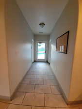 Corridor with baseboards and light tile patterned floors