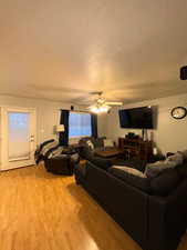 Living area featuring light wood-style floors and ceiling fan