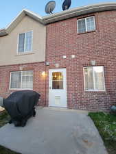 Rear view of property featuring a patio area and brick siding