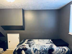 Bedroom four with a textured ceiling and carpet floors