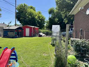 View of yard with a garden, storage shed and chicken coops