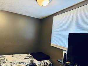 Bedroom  four featuring a textured ceiling