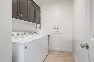 Laundry area with independent washer and dryer, cabinet space, and baseboards
