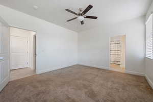 Unfurnished room featuring carpet floors, ceiling fan, a smoke detector, and baseboards