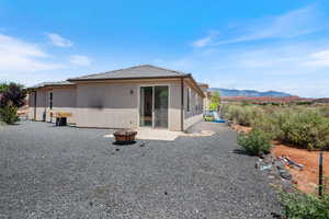 Back of house with a fire pit, a mountain view, stucco siding, a tiled roof, and a patio