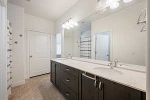 Full bathroom with double vanity and curtained shower
