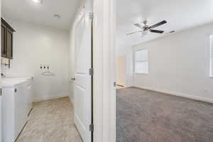 Laundry room with independent washer and dryer, cabinet space, ceiling fan, and baseboards