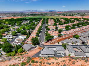Aerial view of property and surrounding area with nearby suburban area and a mountainous background