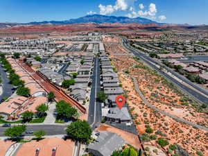 Aerial view of property and surrounding area featuring mountains and nearby suburban area