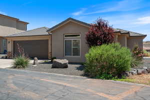 View of front of property with an attached garage, stucco siding, a tile roof, and concrete driveway