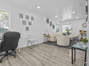 Living area with wood finished floors, recessed lighting, and baseboards