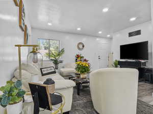 Living room with recessed lighting, wood finished floors, and a textured ceiling