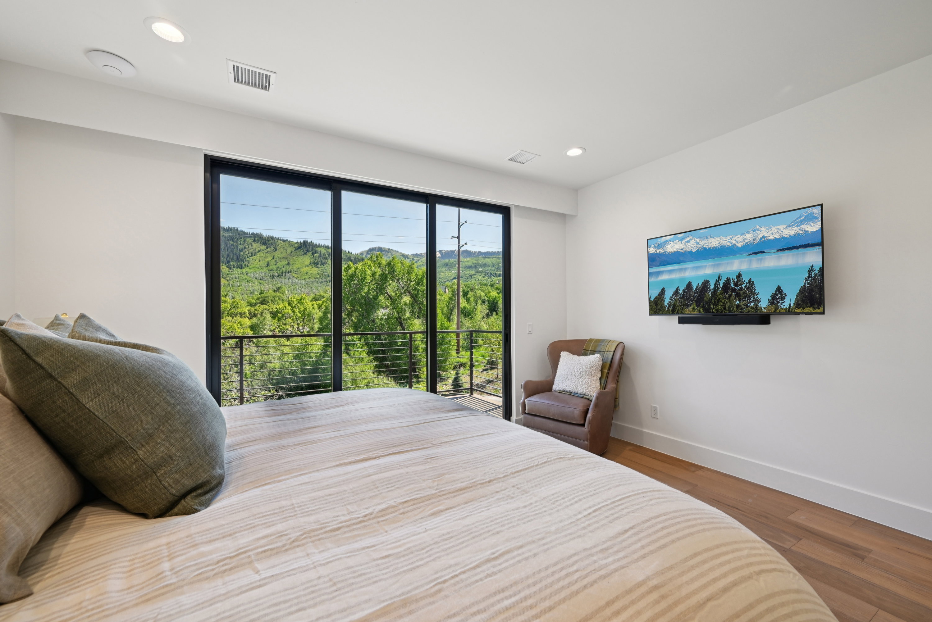 Bedroom with wood finished floors, baseboards, recessed lighting, and access to outside