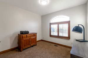 Home office featuring light carpet and baseboards
