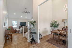 Entryway with wood finished floors, a ceiling fan, high vaulted ceiling, baseboards, and recessed lighting